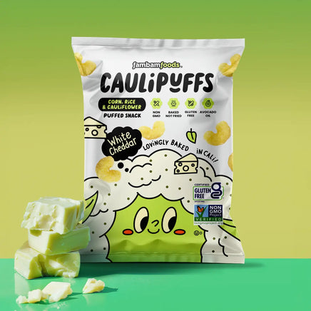 Bag of CauliPuffs White Cheddar against a green gradient background with pieces of white cheddar cheese